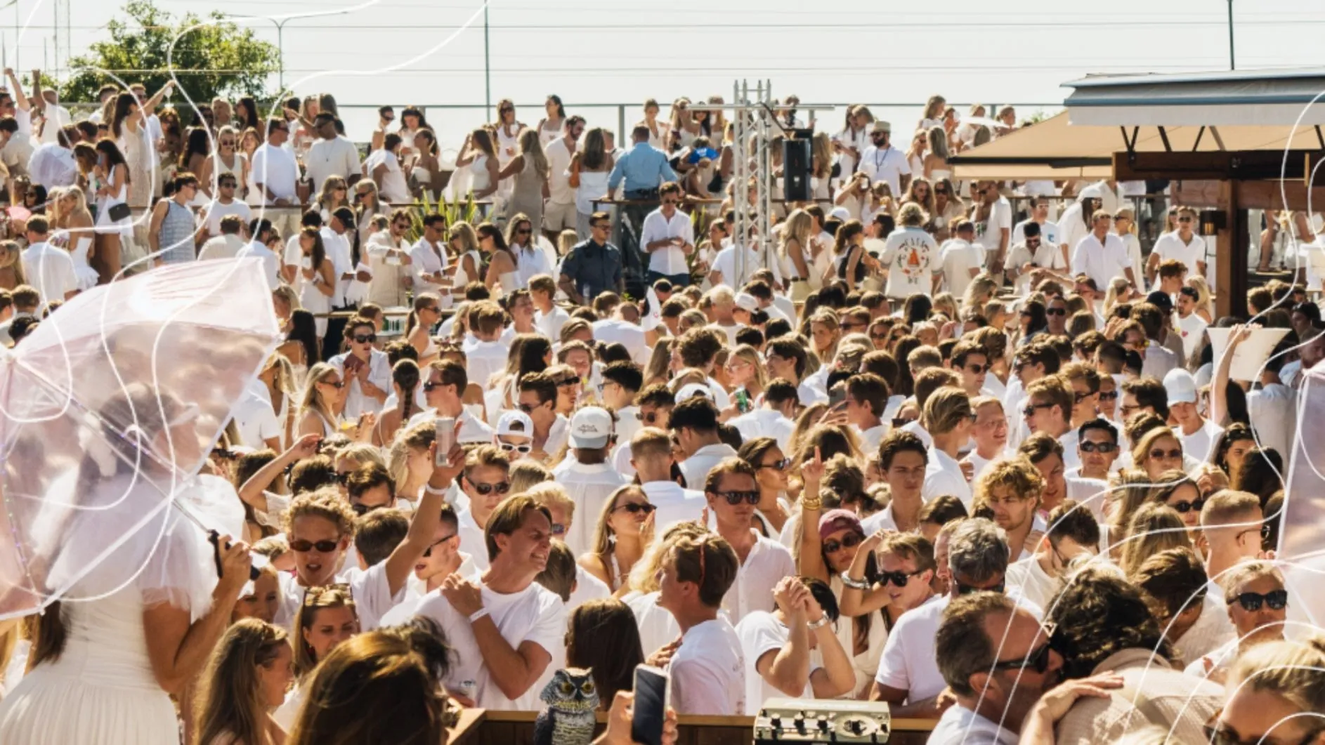 Vitklädd festpublik på en utomhusfest med All White som klädkod