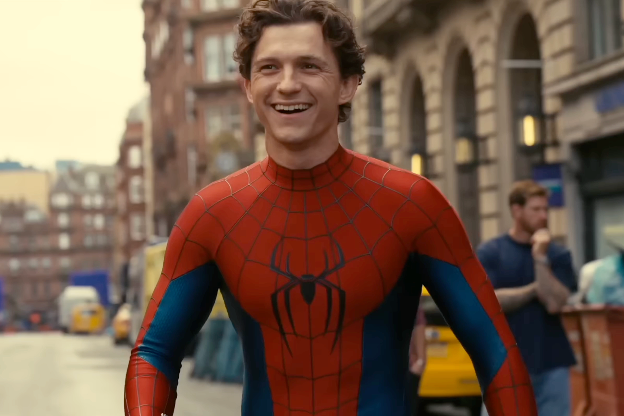 Tom Holland ler i Spider-Man-dräkten på en stadsgata