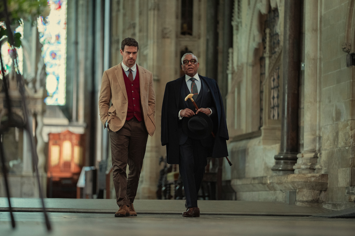Två välklädda män går genom en katedral i Netflixserien The Gentlemen
